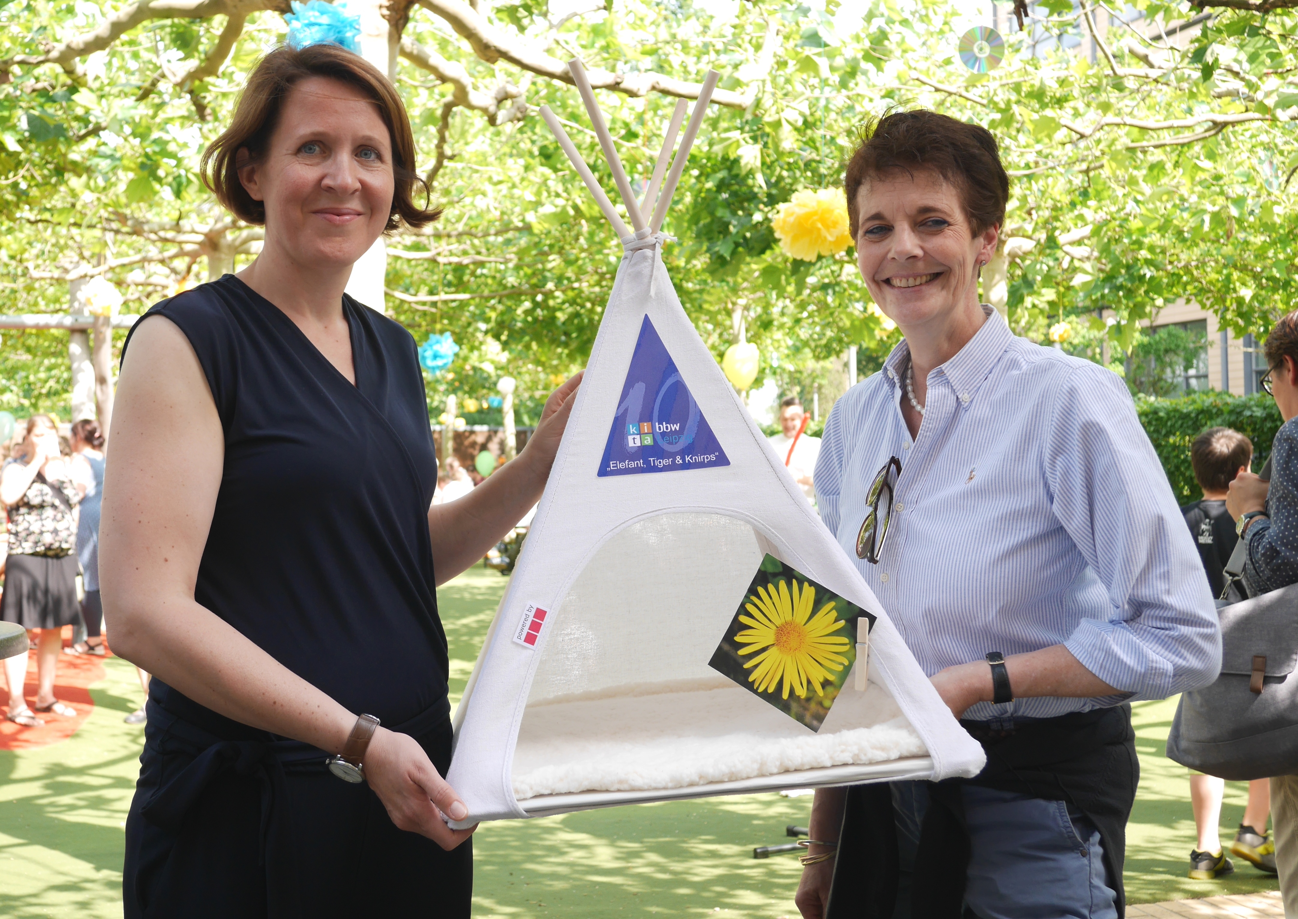 Ulrike von Radowitz, Geschäftsführerin der DREFA Immobilien Management GmbH, überreicht Kitaleiterin Uta Schwager ein Tipi.